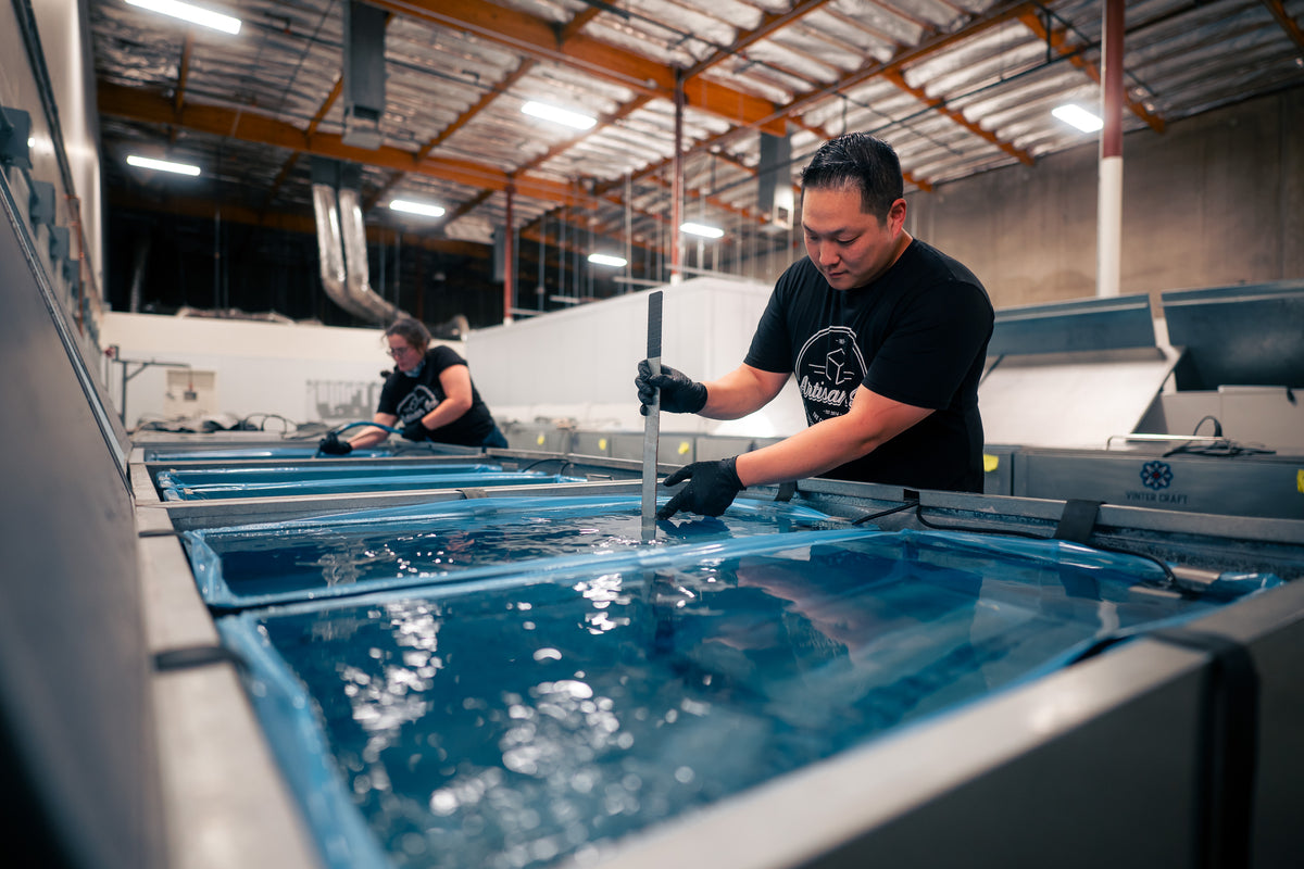 A craftsperson cutting clear ice in a production workshop